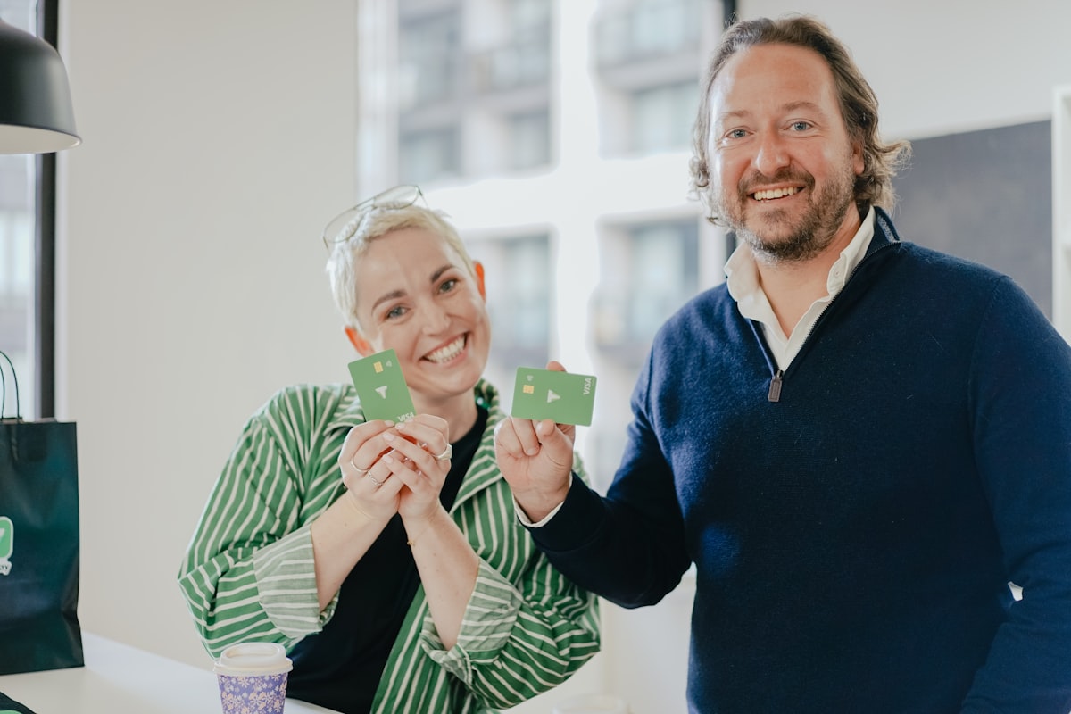 Two people holding loyalty cards from a local business
